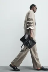 Pantalón de corte straight relaxed fit confeccionado en tejido de lino con efecto lavado. Presenta cierre frontal con cremallera y botón, bolsillos laterales y bolsillos traseros de vivo.