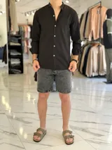 Camisa de lino color beige, de manga larga con puños arremangados y cuello mao. Cuenta con cierre frontal de botones y diseño clásico.