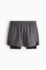 Short deportivo gris con calza interior negra, corte estándar, con cintura elástica y cordón ajustable.