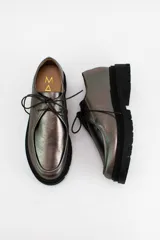 Zapatos tipo wallabee de cuero metalizado en tono peltre, con cordones negros y suela track de goma negra con plataforma.