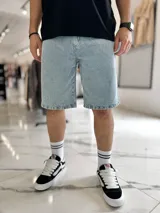 Bermuda baggy de jean en color celeste claro, de corte amplio y largo hasta las rodillas, con diseño clásico de cinco bolsillos y trabillas para cinturón.