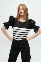 Pantalon cargo de tiro medio confeccionado en lino broderie negro, con bolsillos laterales tipo cargo y diseño de pierna ancha.