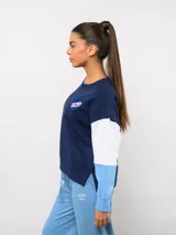 Buzo de cuello redondo con diseño de bloques de color en rojo, blanco y azul. Presenta el logo de Umbro y el escudo del Club Nacional de Football bordados en el pecho.