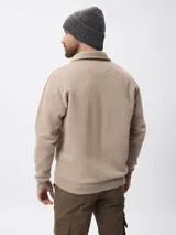 Sweater de felpa color beige, con cuello polo y cierre frontal parcial, de manga larga con puños acanalados.