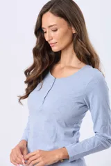 Remera de manga larga color negro, con cuello redondo y cierre frontal parcial con botones a tono. Presenta un diseño de corte recto con ruedo curvo.