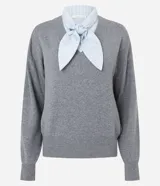 Suéter de punto gris con escote en V y detalle de camisa integrada en color celeste a rayas, con cuello estructurado y lazo frontal. Diseño de corte regular y mangas largas.