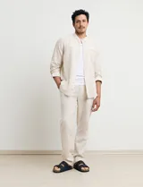 Camisa de cuello mao y manga larga, confeccionada en una mezcla de lino y algodón. Presenta un diseño de corte recto con botones en tono natural y un bolsillo pequeño en el pecho.