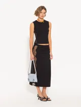 Pollera midi negra ajustada al cuerpo, con elástico en la cintura y recortes laterales de encaje.