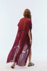 Kimono largo de algodón negro con punto calado, calce amplio, hombros caídos, mangas cortas, aberturas laterales y terminación desflecada en el ruedo.
