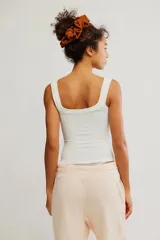 Remera sin mangas blanca de tejido texturado y elastizado, con escote henley y botonadura frontal parcial. Calce ajustado y largo corto.