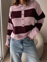 Sweater de tejido bremer con diseño de rayas horizontales anchas en tonos rosado y bordó. Presenta cuello polo con cierre frontal de botones y mangas largas.