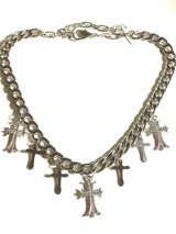 Collar plateado de cadena gruesa con dijes de cruces plateadas, algunas con strass.