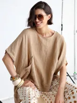 Remera beige de lino, corte amplio, con cuello redondo y bolsillo en el pecho.