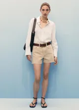 Short de jean de tiro medio, color beige, con diseño de cinco bolsillos, corte recto y bajo deshilachado.