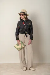 Sombrero de ala ancha color beige con cinta negra.