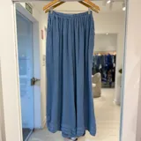 Pantalón ancho de talle alto, color azul jean, con cintura elástica fruncida y bolsillos laterales.