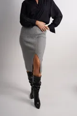 Pollera gris de lanilla con tiro alto, cintura elástica, tejido acanalado y abertura frontal.