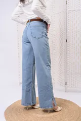 Jeans wide leg de tiro alto en color celeste claro, con corte recto y aberturas laterales en los bajos.