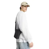Bandolera Puma Buzz de color negro, diseñada con un compartimento principal con cierre, asa de mano superior y correa ajustable para el hombro. Presenta el logotipo de la marca en relieve en la parte frontal.