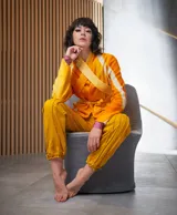 Chaqueta de lana merino afieltrada color naranja con teñido artesanal tie-dye, cuello alto que se prolonga como cinturón y bolsillos laterales.