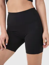 Calza tipo biker de tiro alto en color negro, confeccionada en tejido elástico con banda de silicona interna para mayor sujeción y logo pequeño aplicado en el lateral.