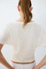 Top blanco de tejido de punto con textura waffle, escote bote y mangas cortas de diseño murciélago.