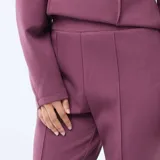 Pantalón de felpa ligera color púrpura, con corte bootcut y costura central vertical en el frente.