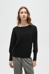 Sweater de tejido de punto color negro, con cuello a la base, corte holgado y mangas largas con puños ajustados.