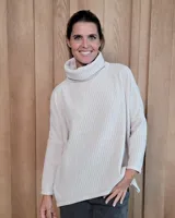 Polera de tejido de punto suave, con cuello alto holgado, mangas largas y corte amplio.
