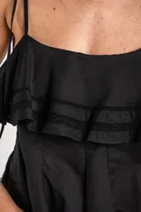 Top negro de 100% algodón, con tirantes finos, escote recto y volados dobles con detalles de encaje en el frente.