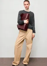 Jersey de punto fino color gris oscuro, con cuello redondo y diseño recto de manga larga.