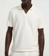 Remera polo de manga corta con cuello tradicional sin botones, confeccionada en tejido con textura mini grid.