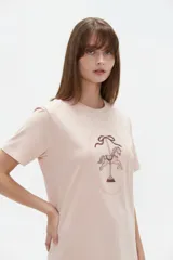 Remera de algodón blanca, de corte holgado, con cuello redondo y diseño estampado en el centro que incluye un gato comiendo de un plato y la inscripción 'Wild Cats'.