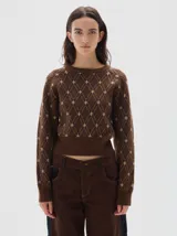 Buzo de punto con cuello redondo y diseño de rombos en jacquard. Presenta puños y ruedo acanalados, con un ajuste corto a la cintura.