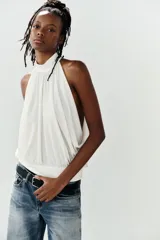 Top halter blanco de diseño fluido con frunces en el cuello, mangas murciélago y bajo con acabado tipo globo.