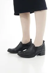 Zapatos de cuero negro con textura de cocodrilo en la puntera y el talón, de corte bajo, con elásticos laterales y taco cuadrado.