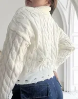 Sweater blanco de tejido de punto trenzado con cuello alto y terminaciones desflecadas.