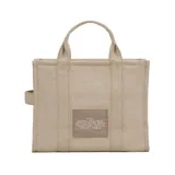 Cartera tote bag Marc Jacobs modelo The Medium Tote Bag, confeccionada en algodón color beige. Cuenta con asas superiores, correa cruzada ajustable y desmontable en color negro, y el texto impreso en contraste en el frente.