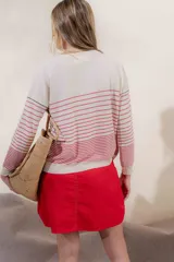 Sweater color crema con rayas horizontales y mangas largas.