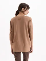 Remera de punto liso y elastizado color marrón tostado, con fit amplio, escote en V y mangas tres cuartos con costuras caídas.