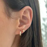 Par de aros pequeños con forma de estrella de cinco puntas, con incrustaciones de circonitas y acabado en oro de 18k.