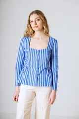 Blusa de manga larga con estampado de rayas verticales en tonos azul y blanco. Presenta un escote cuadrado, cierre frontal con botones y un diseño con corte peplum en la cintura.