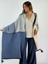 Pashmina de algodón con diseño de bloques de color en azul, gris y beige, con bordes en azul marino y borlas decorativas en los extremos.