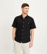 Camisa de hombre de manga corta color marrón, confeccionada en lino y algodón. Presenta cuello clásico, botonadura frontal, bolsillo en el pecho y mangas con botón para enrollar.