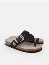 Sandalia de dedo color negro, confeccionada en cuero grabado, con plantilla anatómica, suela de corcho y hebilla ajustable con detalles metálicos estilo cowboy.