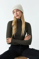 Polera de manga larga ajustada al cuerpo, confeccionada en tejido rib de algodón. Presenta cuello alto y diseño corto tipo crop top.