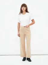 Pantalón beige de corte acampanado con bolsillos delanteros con solapa y botón.