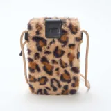Bolso bandolera para teléfono de textura peluda con estampado animal print de leopardo. Cuenta con una solapa superior de cuero sintético negro y correa de cordón ajustable en color beige.