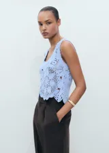 Top de crochet celeste con diseño floral, escote redondo y sin mangas.
