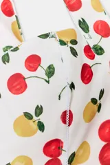 Body blanco con estampado de cerezas y limones, cuello halter y escote pico.